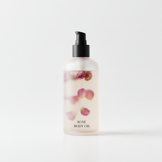 Bottle of Rose Body Oil with rose petals suspended inside and a black pump dispenser on a white background